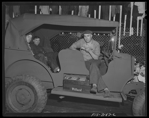 Dodge truck plant, Detroit, Michigan. Workers eating lunch on uncushioned seats of a half-finished command reconnaissance car