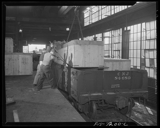 Detroit, Michigan (vicinity). Chrysler Corporation Dodge truck plant. Using crowbars to fit export crates closely on a freight car