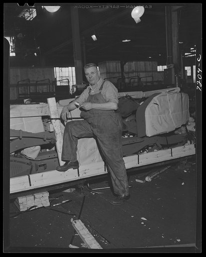 Dodge truck plant, Detroit, Michigan. Dodge worker whose job it is to check shipping crates to see that nothing is omitted