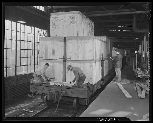Detroit, Michigan (vicinity). Chrysler Corporation Dodge truck plant. Securing crates to freight car and checking numbers of vehicles being shipped