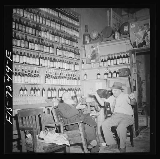 Untitled photo, possibly related to: New York, New York. Rabbi in the Jewish section passing the time of day with the proprietor of a kosher wine shop where sacrificial wines are sold