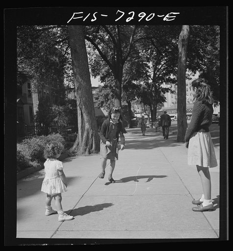 New York, New York. Chinese-American girl playing hopscotch with American friends outside her home in Flatbush