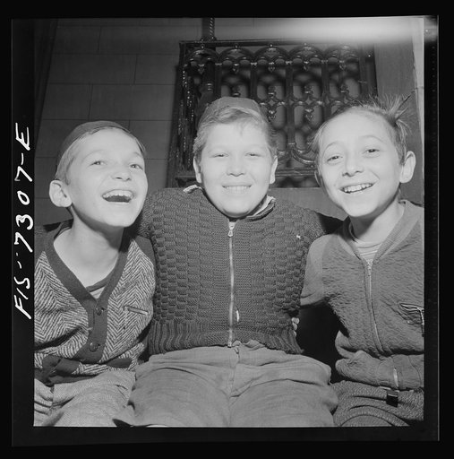 New York, New York. Jewish boys sitting on the synagogue steps at night in the Jewish section