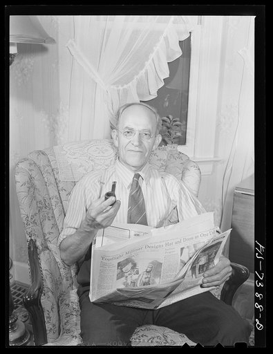 Cass Lake, near Pontiac, Michigan. Karl Axel Westerberg relaxing with the evening paper at his home after a day's work at the Johansson gauge division of the Ford Motor Company, where he is foreman of the rough stock department