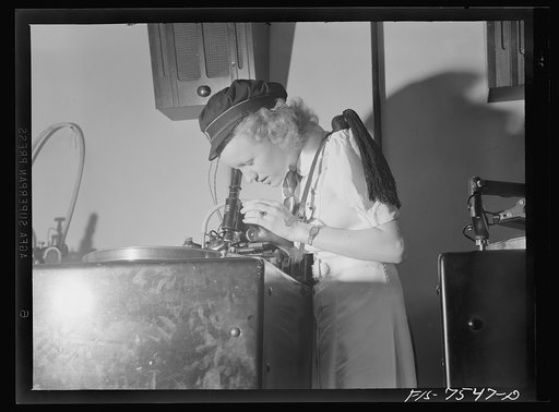 Washington, D.C. Foreign students at the international student assembly recording short talks in their native language to be broadcast by shortwave, after censorship by the Office of War Information (OWI), to Nazi-held territory. Filla and Toy, Norwegians, examining the cut in the recording through 