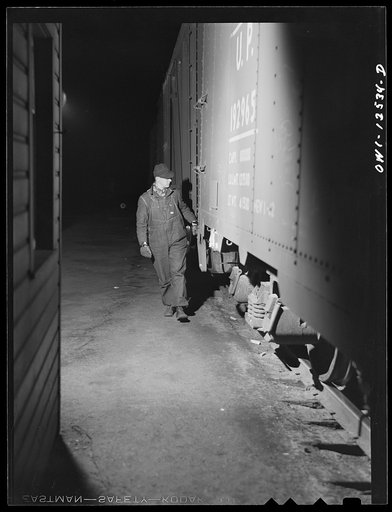 Chicago, Illinois. Hump helper uncoupling cars as they come over the hump at the Chicago and Northwestern Railroad yard