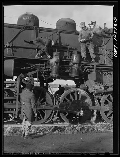 Chicago, Illinois. Engineer and fireman thawing out air compressors on a cold morning at a Chicago and Northwestern railroad yard