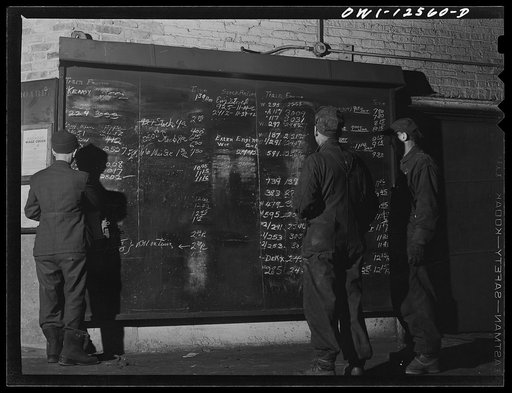 Chicago, Illinois. Workers studying the work schedule bulletin board at the roundhouse at a yard of the Chicago and Northwestern Railroad