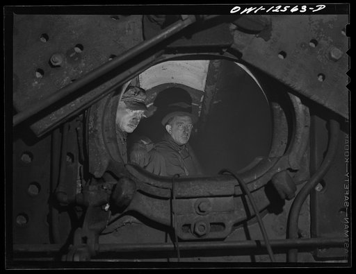 Chicago, Illinois. Boiler makers inside the firebox of a locomotive on which they have been working at the roundhouse at a yard of the Chicago and Northwestern Railroad