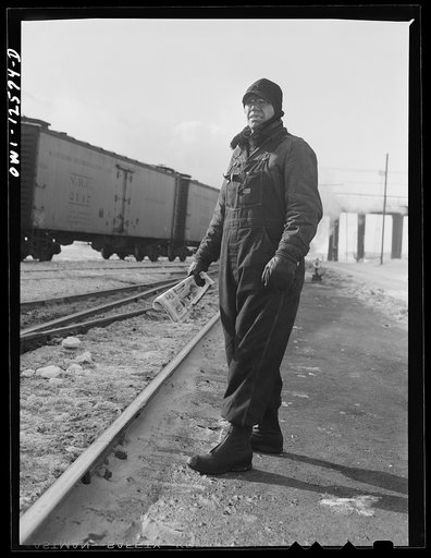 Chicago, Illinois. Switchman waiting for the train he is to work to come down the tracks at a yard of the Chicago and Northwestern Railroad