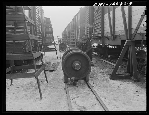 Chicago, Illinois. Bringing in a new pair of wheels to replace the old ones on a freight car on the repair tracks at a yard of the Chicago and Northwestern Railroad