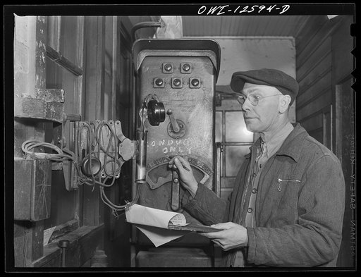 Chicago, Illinois. Hump master in a Chicago and Northwestern Railroad yard operating a signal switch system which extends the length of the hump track. He is thus able to control movements of locomotives pushing the train over the hump from his post at the hump office