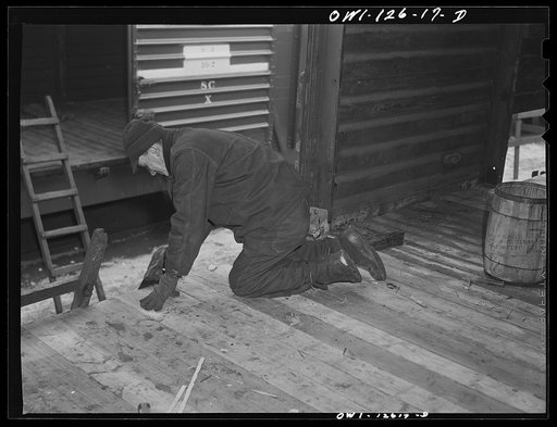 Chicago, Illinois. Putting a new floor in a freight car on the repair tracks at a yard of the Chicago and Northwestern Railroad