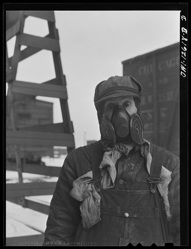 Chicago, Illinois. One of the painters at the repair tracks at a yard of the Chicago and Northwestern Railroad. The mask is worn as a protection when spraying paint on cars