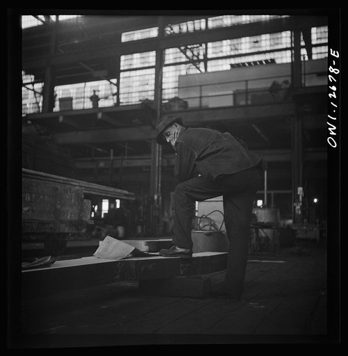 Untitled photo, possibly related to: Chicago, Illinois. Workmen studying blueprints in the Chicago and Northwestern Railroad repair shops