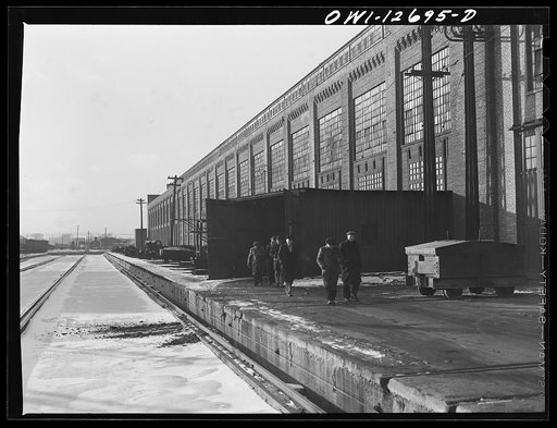 Workmen coming out of locomotive shops at the end of the shift at 40th Street shops, Chicago and Northwestern Railroad