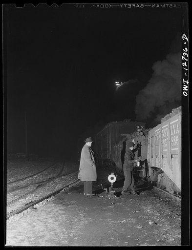 Chicago, Illinois. The general yardmaster comes to supervise personally the handling of some military equipment at one of the Chicago and Northwestern Railroad classification yards