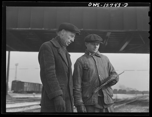 Chicago, Illinois. Yardmaster (left) discussing a switch list with a train clerk at a Chicago and Northwestern Railroad yard