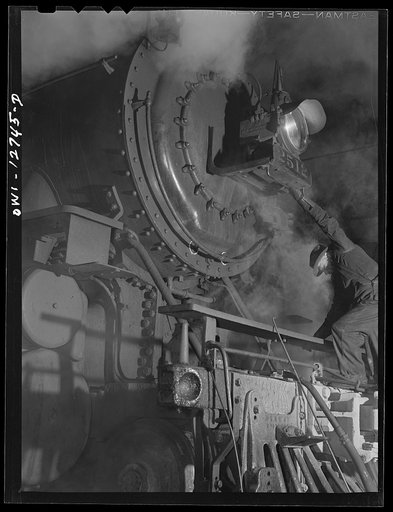 Untitled photo, possibly related to: Chicago, Illinois. Servicing an engine at the roundhouse at a Chicago and Northwestern Railroad yard