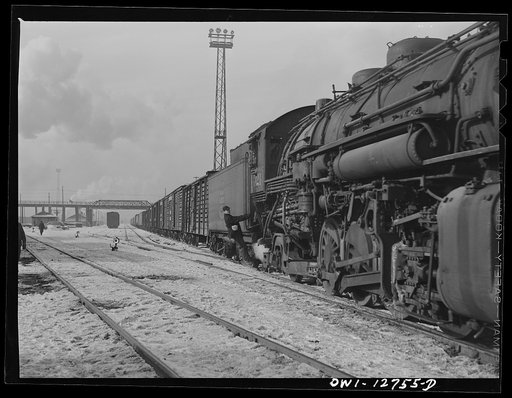 Chicago, Illinois. An Indiana Harbor Belt Line railroad engine delivering a trainload of stock and other cars at a yard of the Chicago and Northwestern Railroad. Riding with the engine is the headman