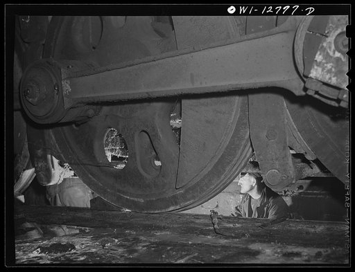 Chicago, Illinois. Working on the underside of a locomotive in a pit at the roundhouse at the Chicago and Northwestern Railroad yard