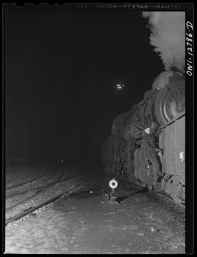 Chicago, Illinois. Switchman riding a car in one of the Chicago and Northwestern Railroad classification yards