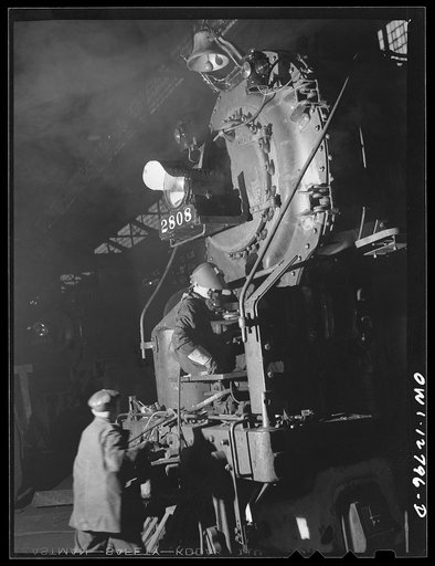 Untitled photo, possibly related to: Chicago, Illinois. Servicing an engine at the roundhouse at a Chicago and Northwestern Railroad yard