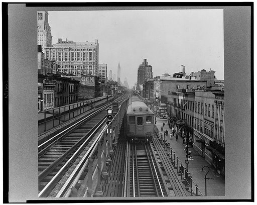 New York, New York. Looking north from the Ninth Street station on the Third Avenue elevated railway as a train leaves on the local track