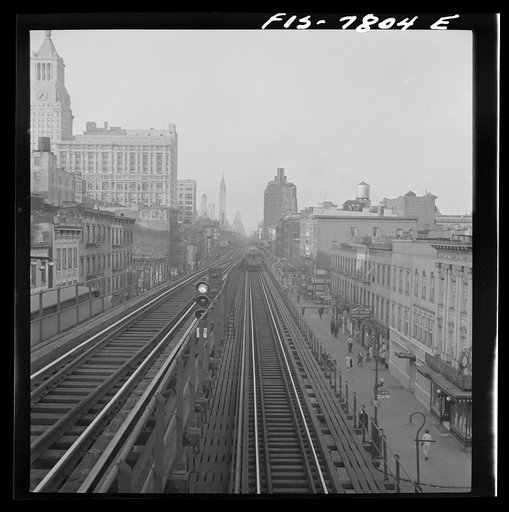 New York, New York. Looking north from the Ninth Street station on the Third Avenue elevated railway as a train leaves on the local track