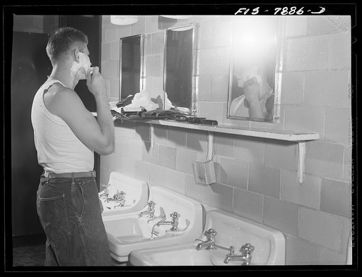 Untitled photo, possibly related to: Fort Belvoir, Virginia. Sergeant George Camblair shaving in the morning at the camp