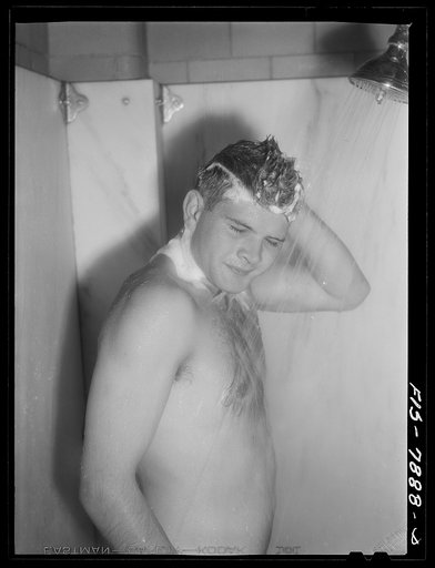 Fort Belvoir, Virginia. Sergeant George Camblair taking a shower at camp