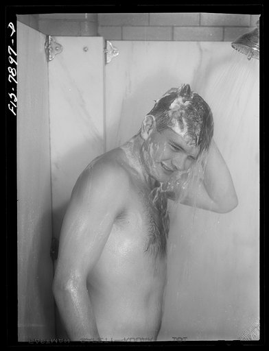 Fort Belvoir, Virginia. Sergeant George Camblair taking a shower before dinner at camp