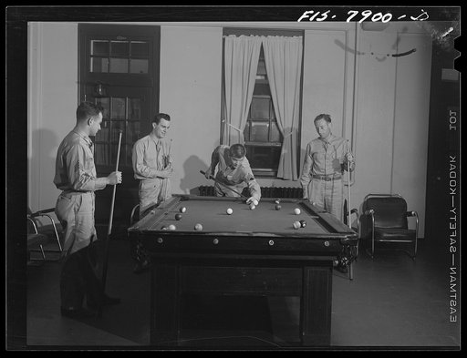 Fort Belvoir, Virginia. Sergeant George Camblair playing a game of billiards with friends in the recreation room while waiting for mess call