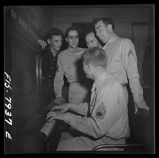 Untitled photo, possibly related to: Fort Belvoir, Virginia. Sergeant George Camblair trying hard to provide an accompaniment for his friends' singing