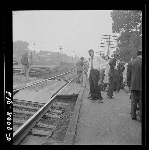 Silver Spring, Maryland. George Camblair waiting at the station for the train which will take him to the induction center