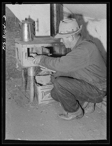 Gravelly Range, Madison County, Montana. Sheepherder builds fire to cook supper at his camp