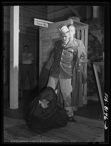 Fort Belvoir, Virginia. Issuing an overcoat to George Camblair at the clothing warehouse