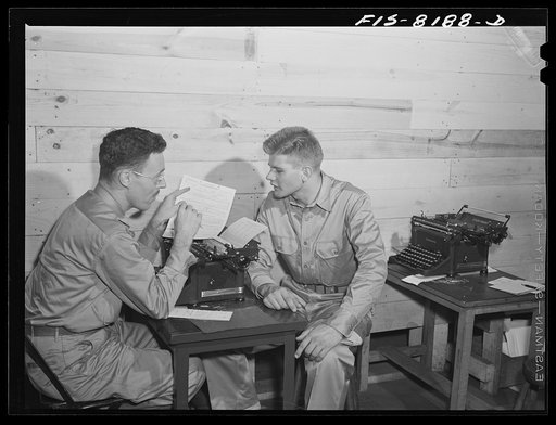 Untitled photo, possibly related to: Fort Belvoir, Virginia. George Camblair discussing insurance problems with an officer at the reception center