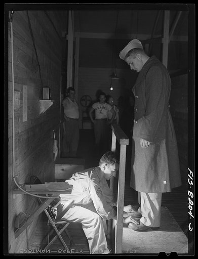 Fort Belvoir, Virginia. A corporal seeing that George Camblair's shoes are a proper fit at the clothing warehouse