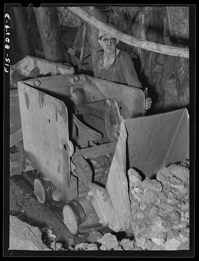Untitled photo, possibly related to: Butte, Montana. Anaconda Copper Mining Company. Miner using automative mucking machine to load cars in a copper mine