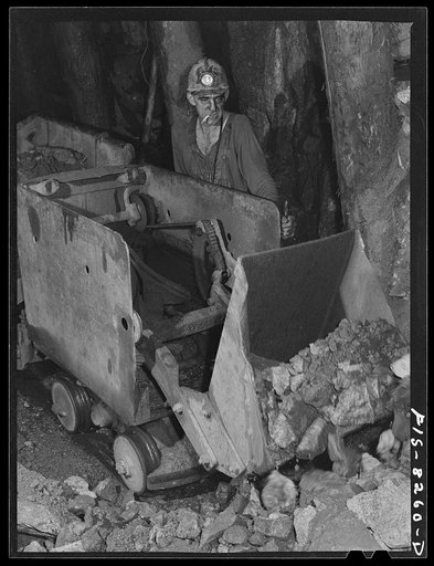Butte, Montana. Anaconda Copper Mining Company. Miner using automatic mucking machine to load cars in a copper mine