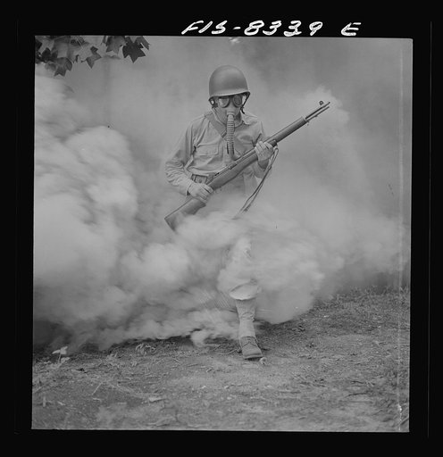 Fort Belvoir, Virginia. Sergeant George Camblair learning how to use a gas mask in a practice smokescreen