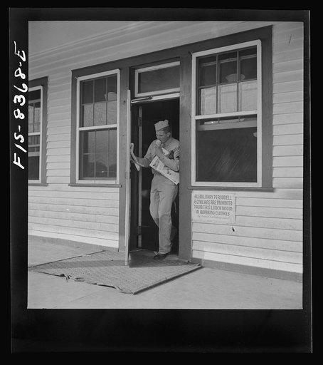 Fort Belvoir, Virginia. Sergeant George Camblair getting some magazines and an ice-cream cone at the post exchange