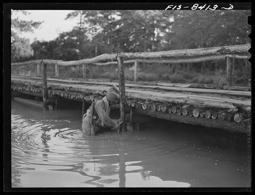 Untitled photo, possibly related to: Fort Bragg, North Carolina. Parachutist dynamiting a bridge in a military demonstration