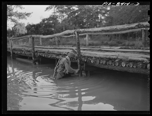 Untitled photo, possibly related to: Fort Bragg, North Carolina. Parachutist dynamiting a bridge in a military demonstration