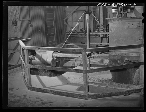 Anaconda smelter, Montana. Anaconda Copper Mining Company. Automatic sampler at end of conveyor belt; by this device, which gathers and drops a sample into a hopper, precise information is obtained concerning the content of copper and other metals in the ore