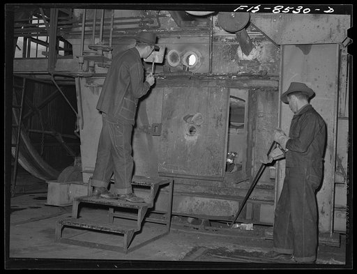 Anaconda smelter, Montana. Anaconda Copper Mining Company. Workman inspecting the roasting process of manganese ore, which is a carbonate of manganese called pink rhodochrosite