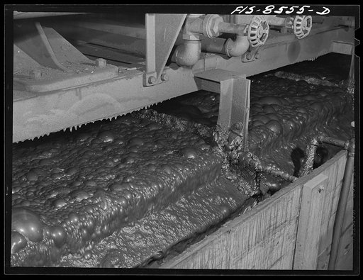 Anaconda smelter, Montana. Anaconda Copper Mining Company. Flotation machine in which particles of copper sulphide ore are attracted to the oily bubbles which retain the minerals by the process of adsorption; the ore floats and is skimmed off from the gangue, which remains submerged and it (the gang
