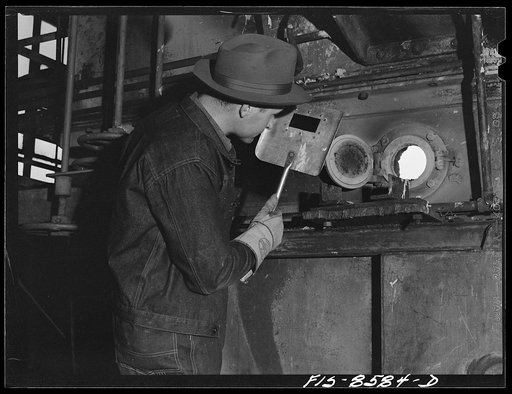 Anaconda smelter, Montana. Anaconda Copper Mining Company. Experienced workman watches the color of roasting manganese ore through oven door
