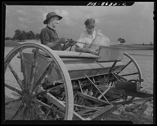 Untitled photo, possibly related to: Beltsville, Maryland. Employees of the United States Department of Agriculture experimental farm demonstrating the care and repair of farm machinery for posters to be used in a "Share and Repair" conservation program